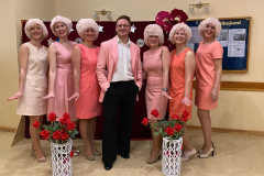 Skolotāji pārģerbušies rozā skatuves tērpos