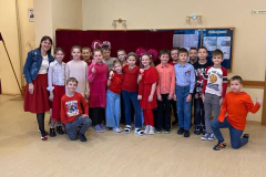 3.a klase ar klases audzinātāju ģērbušies sarkanos toņos fotogrāfējas 