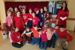 3.b klase ar klases audzinātāju ģērbušies sarkanos toņos fotogrāfējas 