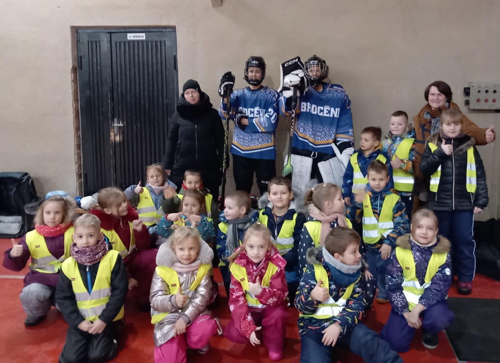 Sešgadnieku, hokejistu un audzinātāju kopējs foto sporta zālē